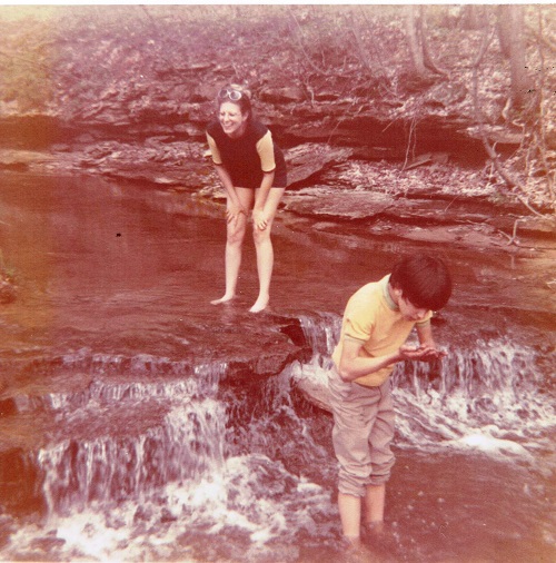 I explore creek invertebrates in the sand while my cousin laughs from the top of Hetripsand Falls. What we named the little waterfall.