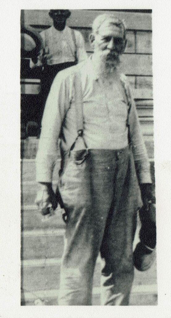 "Grandpa" Askin's with a masonry trowel in hand, standing before an Asbury College building he helped build in about 1913. 