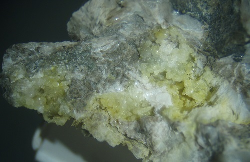 Greenockite (CdS) colors smithsonite, giving it a yellow hue. On smithsonite. From the quarry in Danville, KY.