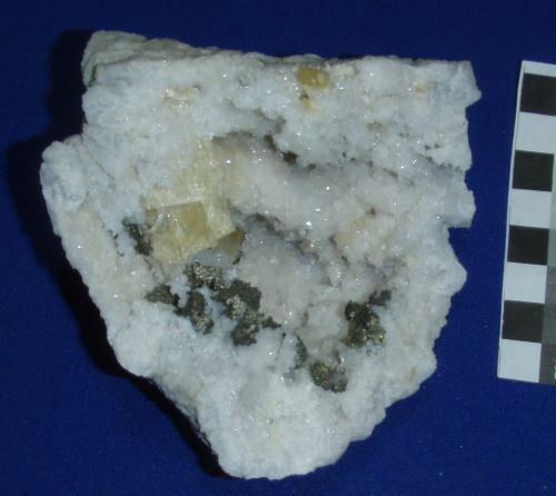 Pyrite in small crystal clusters. Their shape resembles dolomite aggregates, so they might be pseudomorphs from dolomite that became ankerite or siderite. With yellow barite on quartz, Calcite removed with HCl. Harrodsburg, Indiana. 