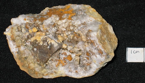 Fluorite is the brownish block in the lower left, an etched crystal. Also present are spheres of calcite and brown goethite.