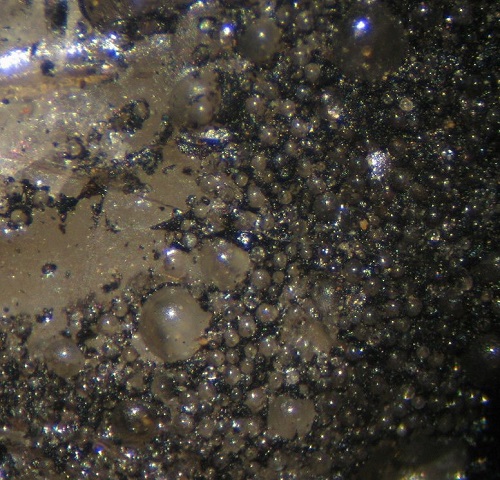 Photo Hy1, Bitumen (dried hydrocarbons) around calcite spheres, from the Hastie's property, collected in 1984. FOV ~ 7.