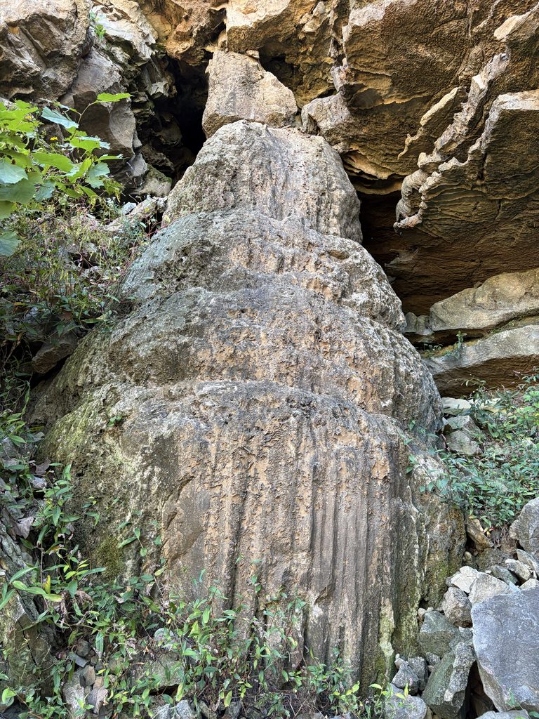 A weathered stalagmite  and other speleothems to the right, on the east high wall. 